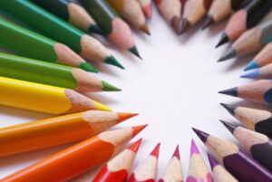 A circle of colored pencils arranged in the shape of a heart.