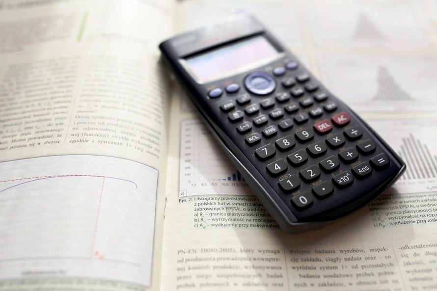 A calculator sitting on top of an open book.