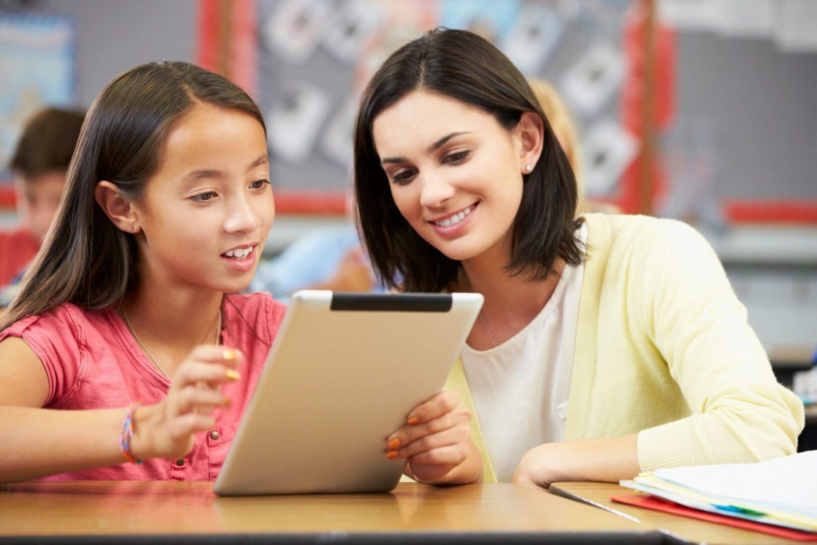 A woman and girl looking at an ipad.